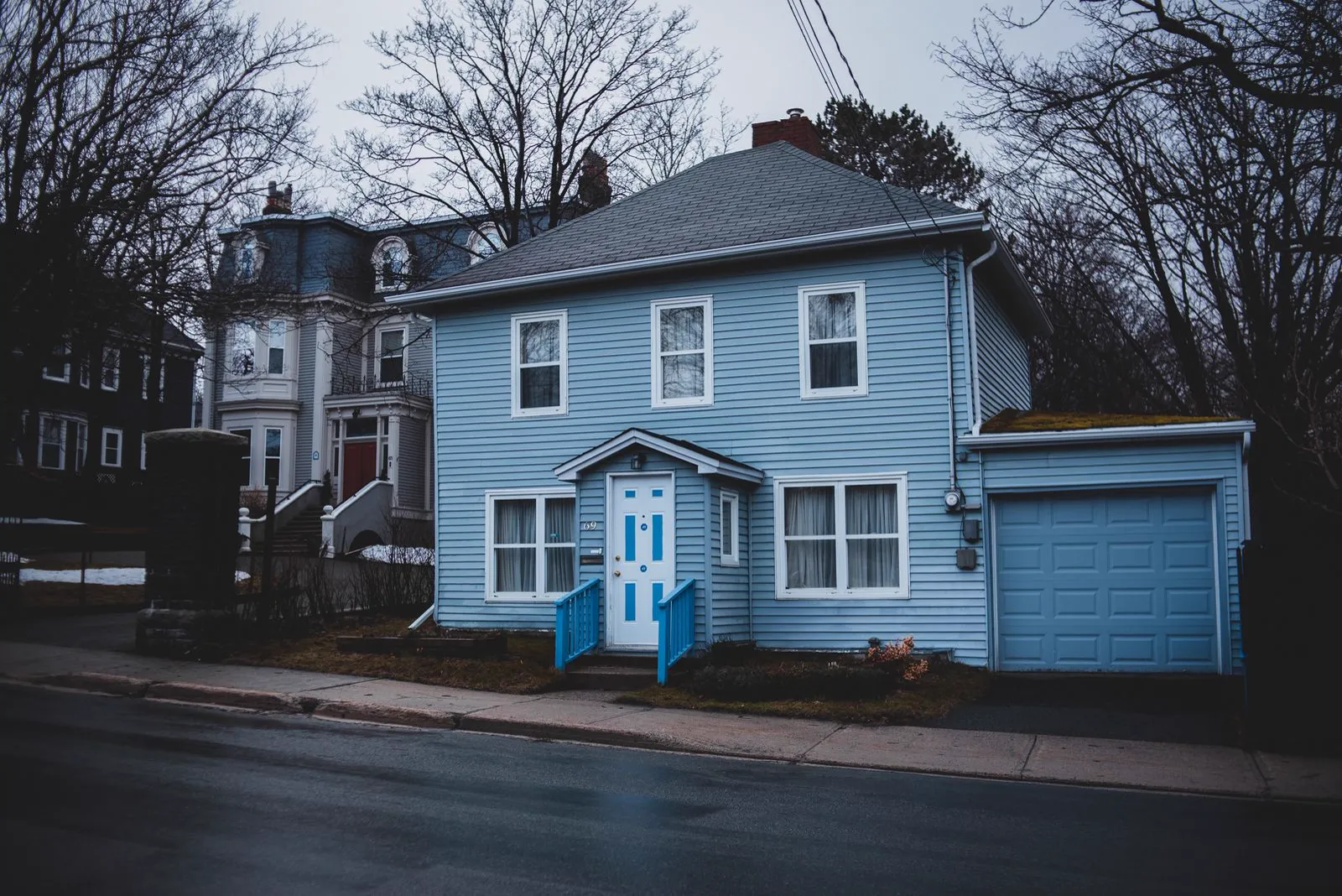 Blue sided house with white trim and an attached garage