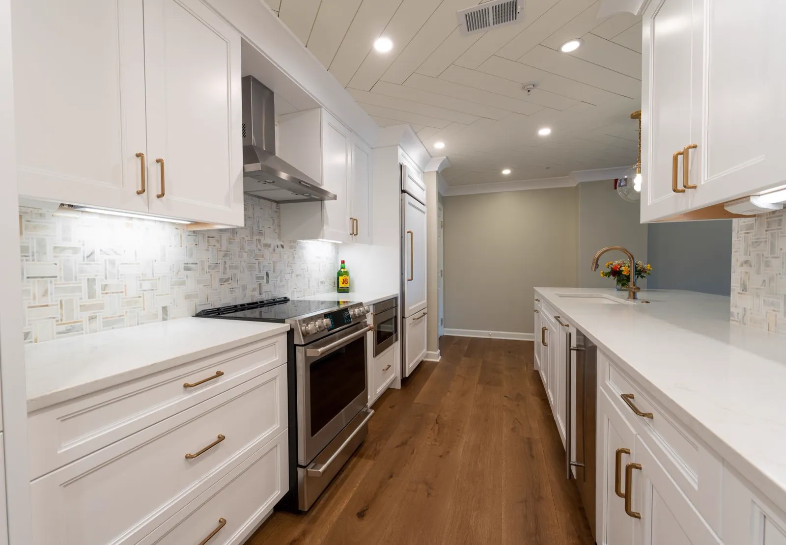 Bright remodeled kitchen with white cabinets and hardwood floors
