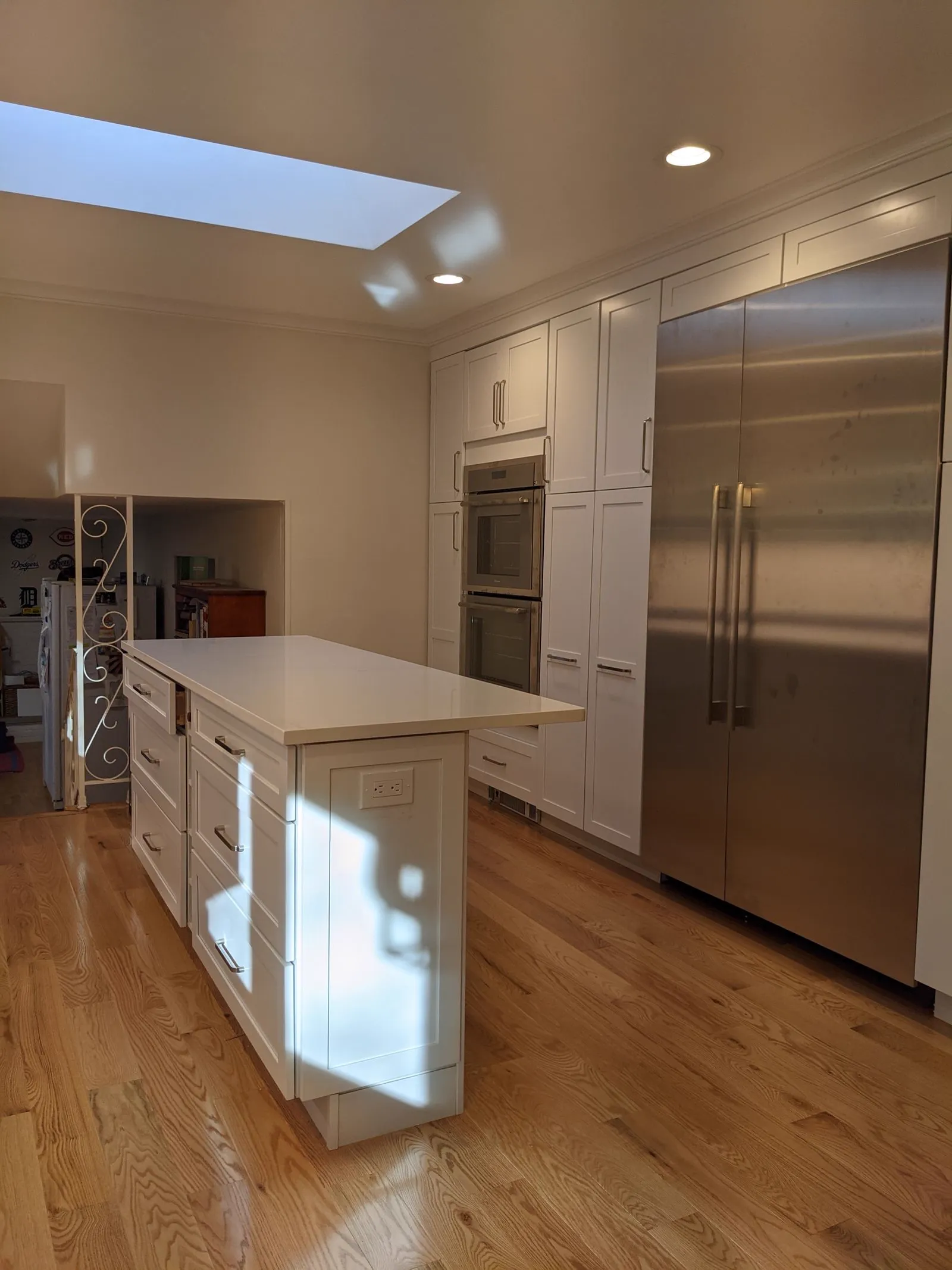 Renovated kitchen with an island, stainless appliances and hardwood floors