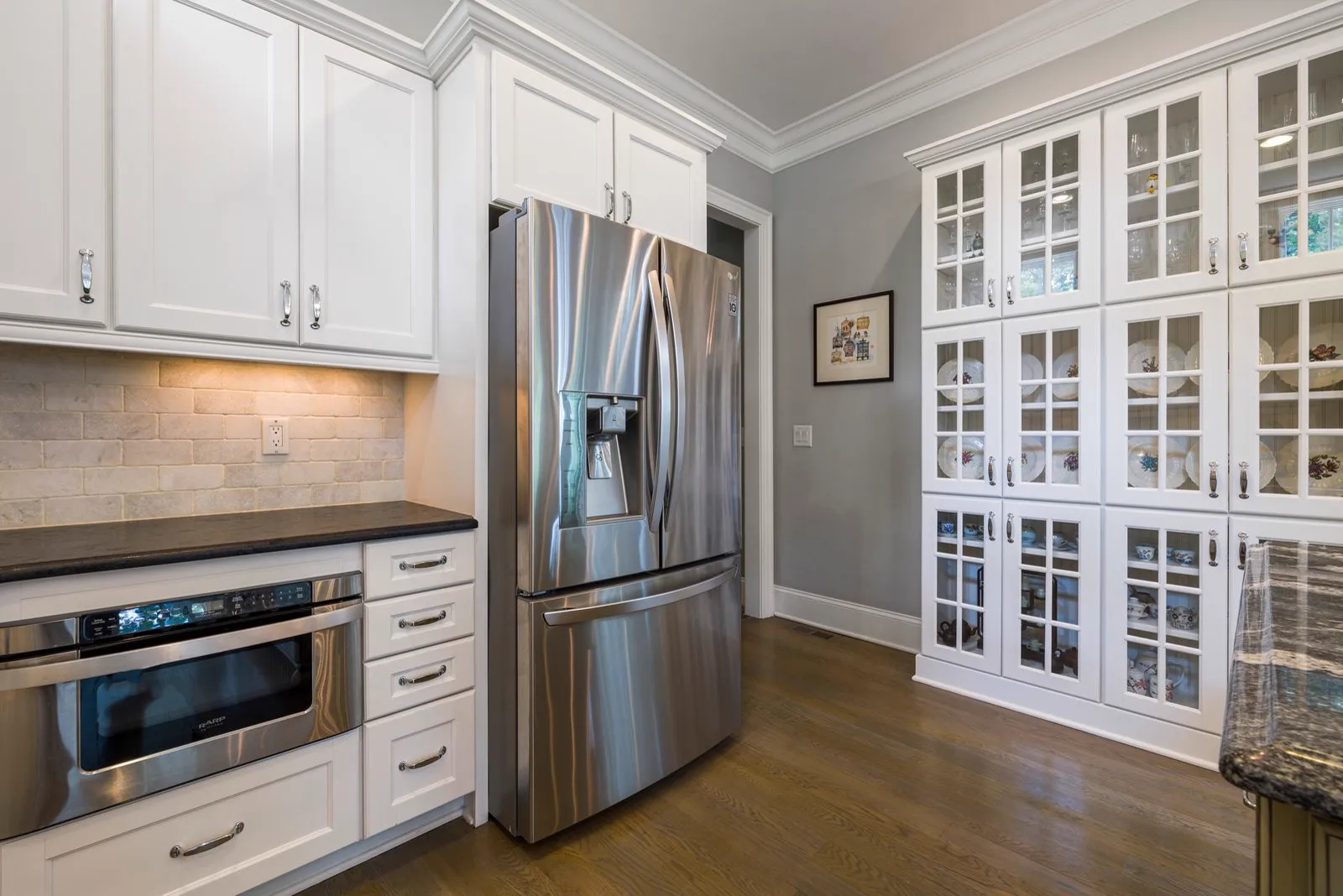 Kitchen with hardwood floors and white shaker cabinets