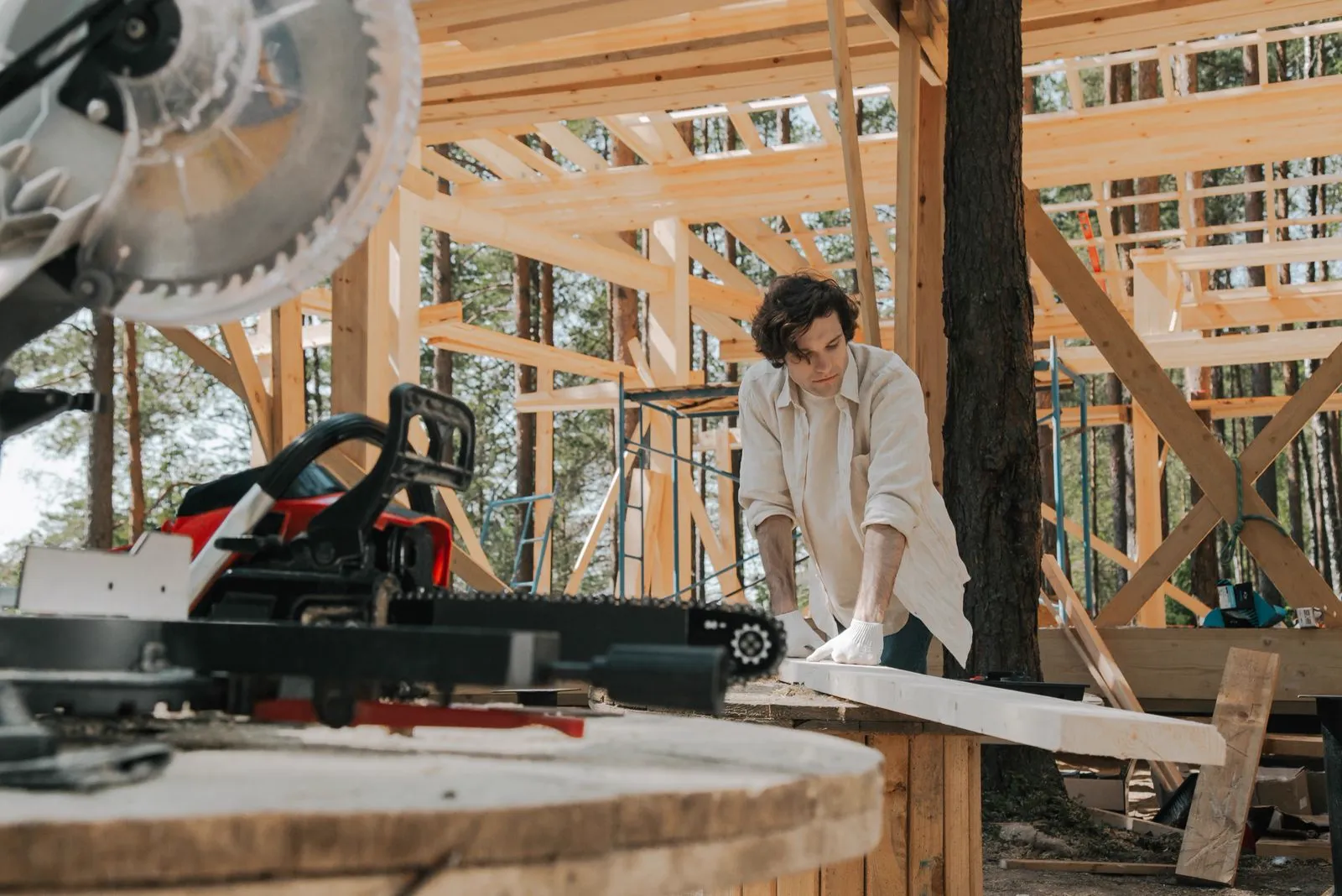 Carpenter cutting lumber with a miter saw on a framing project