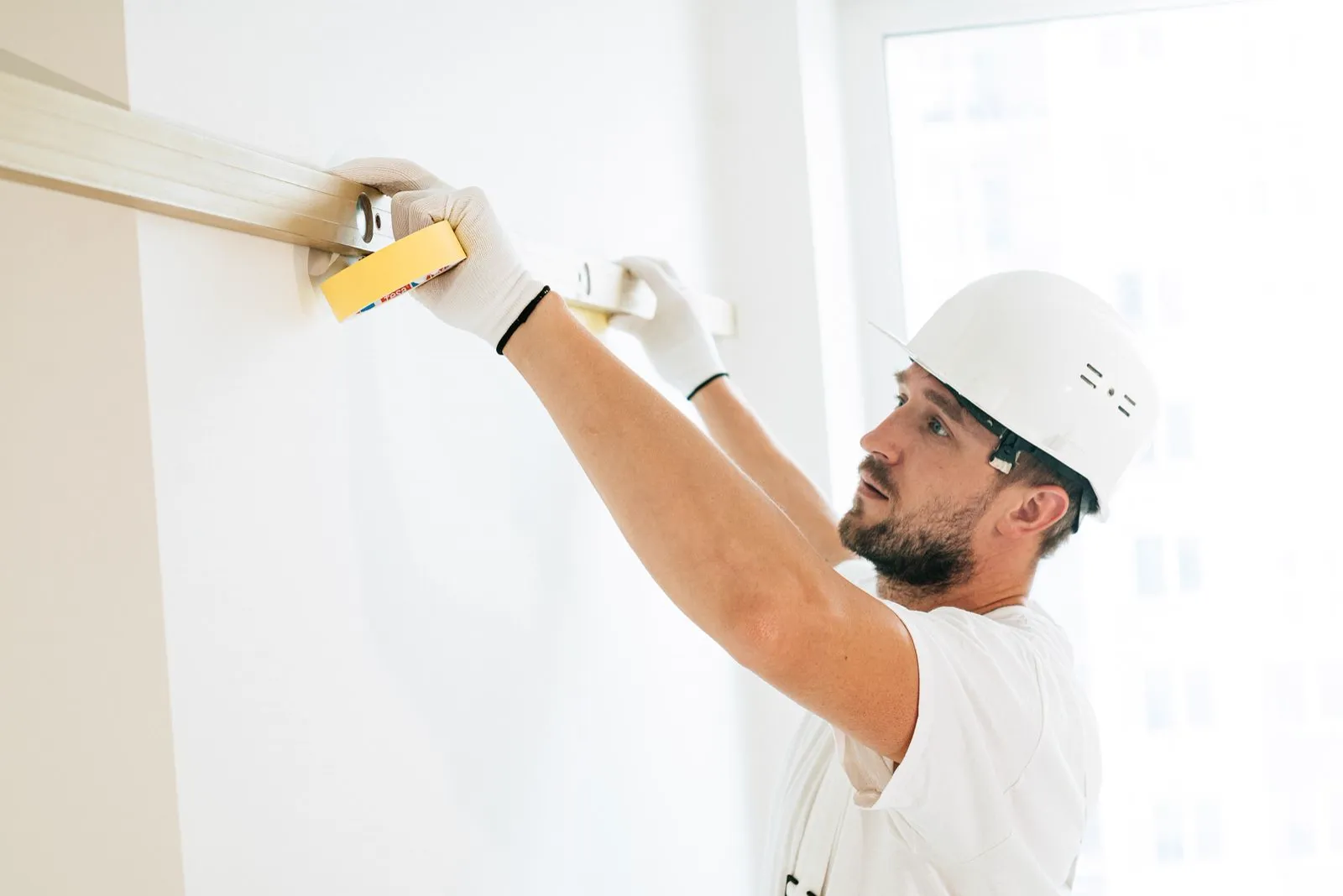 Contractor checking a wall with a level during finishing